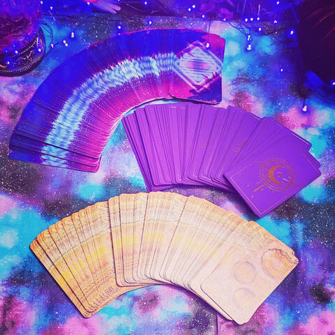 Who am I? circular image of tarot cards fanned out on tablecloth